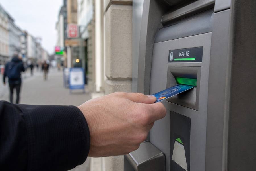 Hand steckt Bankkarte in deutschen Geldautomat